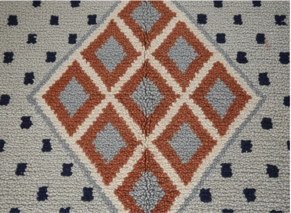 Vue rapprochée des losanges terracotta et gris du tapis Azilal