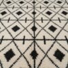 Gros plan sur les losanges et diamants noirs du tapis Beni Ouarain