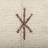 Détail du tissage en laine et d’un signe brun du tapis Beni Ouarain